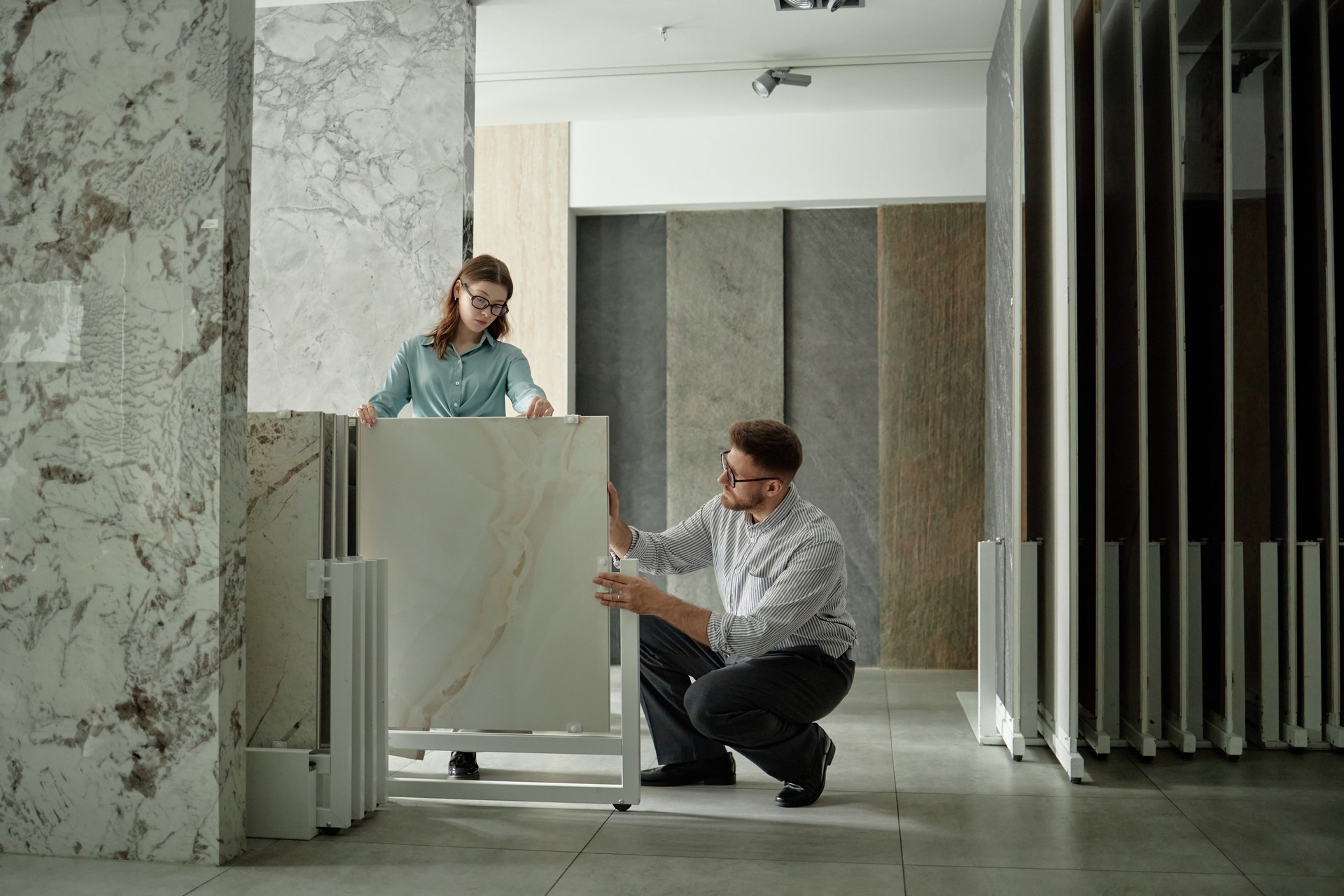 Caucasian Young Woman and Man Examining Marble Tile Samples